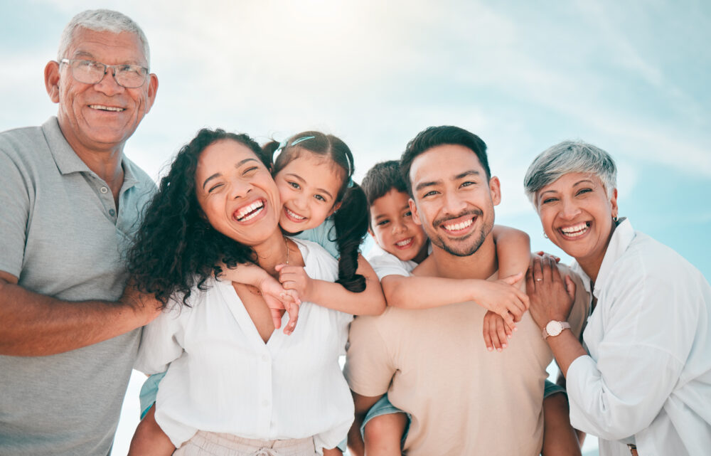 Smiling family in nature, proudly displaying the healthy, well-aligned smiles made possible through orthodontic care.