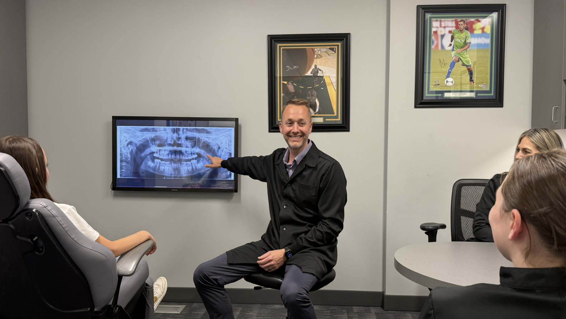 Orthodontist Dr. Lowe smiling during a consultation, reviewing personalized treatment plans to help patients achieve confident, healthy smiles.