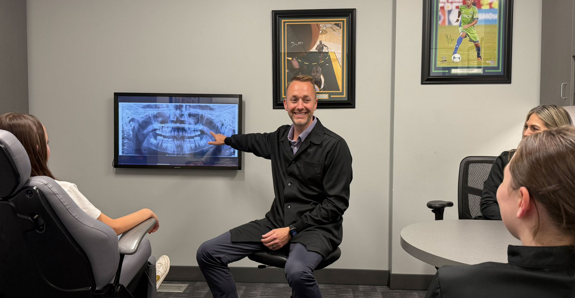 Orthodontist Dr. Lowe smiling during a consultation, reviewing personalized treatment plans to help patients achieve confident, healthy smiles.